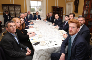 Secretary of State and NI party representatives sit around a table, facing the camera.